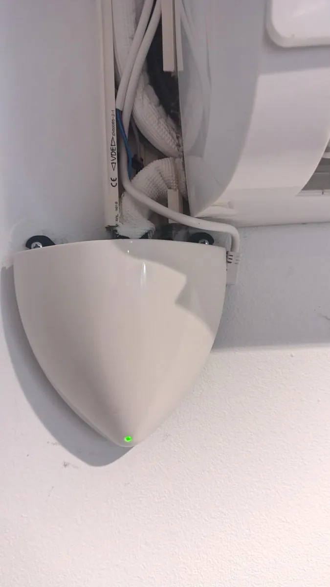 Bomba de condensados instalada bajo la unidad interior de un aire acondicionado de pared